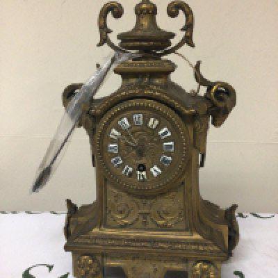 A brass cased French clock late 19th century the sides with rams heads and surmounted with an ornate finial with pendulum height 34cm