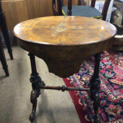 A Victorian walnut workbox the oval hinged top enclosing an elaborate satinwood interior on turned supports.