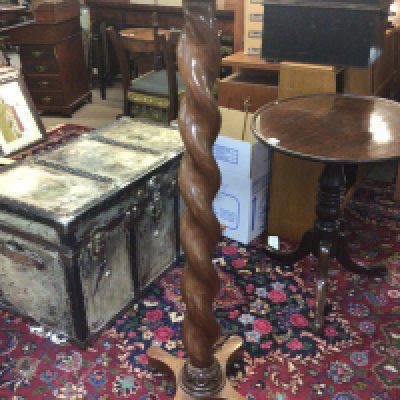 A Walnut plant stand or torcher with a barley twist coloum. Height 126cm