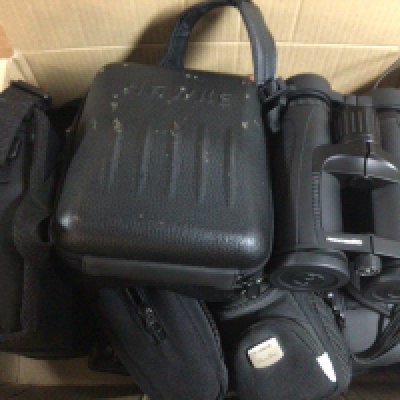 A box containing a collection of cameras and binoculars Canon Frontier binoculars and others.