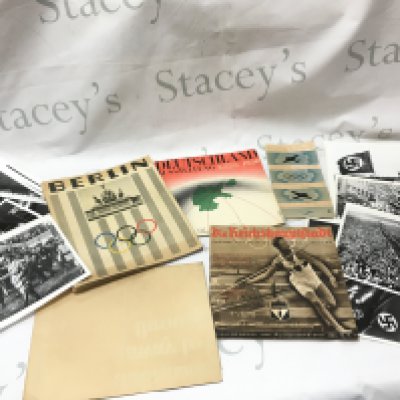 A collection of Nazi Germany ephemera including a Berlin Olympics Photo book Berlin by Hitlers photographer Heinrich Hoffmann with a foreword by Joseph Goebbels. Printed: Berlin, Verlag Heinrich Hoffmann in 1936, Herbert Bayer Deutschland Ausstellung 1936, Deutsche Lufthansa April 1936 airline time table schedule brochure, The Reich Capital 31/1936 &#2013265924&#2013265923&#2013265921 Official Organ of the Berlin (Berliinin olympialaiset) booklet. British HM stationary be on your guard poster , imperial war museum prints. Postage category B