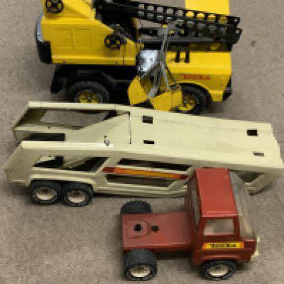 A vintage Tonka grab lorry together with a Toy tractor and car trailer.