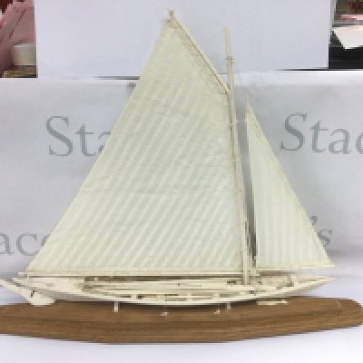 A whalebone model whaling boat complete with oars, ropes, spears etc and raised on a wooden base. Total length approx 60cm. Shipping category D.