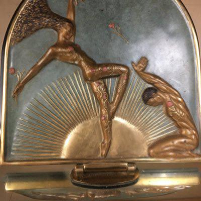 A Art deco Femme Fatale bronze revolving table mirror designed by Erte Romain de Tirtoff Depicting two dancers in front of a gilt sunburst. 40 x 42 cm 34 cm heigh .