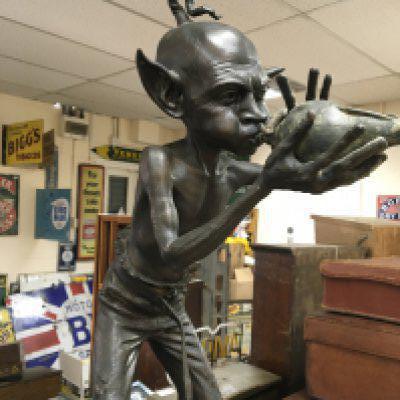 In the style of David Goode, a bronze figure in the form of a goblin playing a conch shell 84 cm