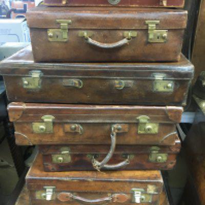 A collection of eleven vintage suite cases and traveling trunks .