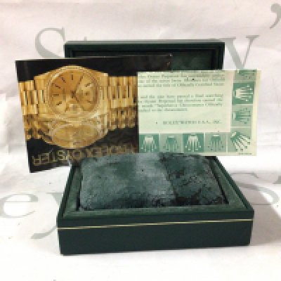 A vintage Rolex box with documents.