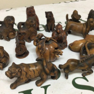 A collection of carved wood Japanese Netsuke in the form of animals birds and one figure some with glass eyes and signed bases.