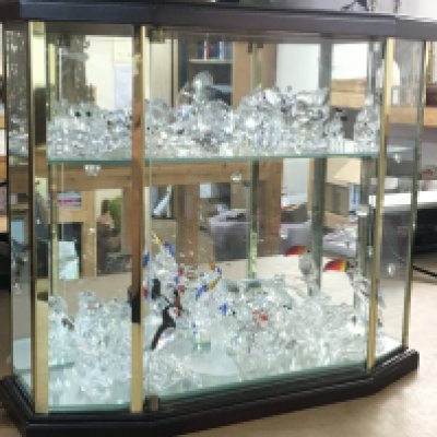 A collection of Swarovski crystal glass animal figures stored in a display case. This lot cannot be posted