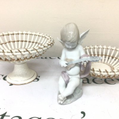 A Lladro figure of a seated cherub playing musical instrument and two white glazed open ceramic baskets no damage (3)