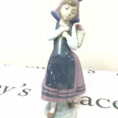 A Lladro figure of a young girl in traditional dress. No obvious damage Hight 26cm