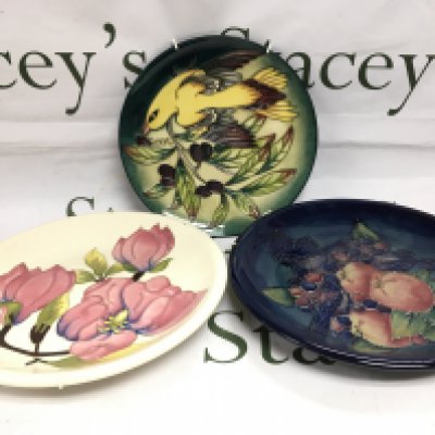 Three Moorcroft plates and a dish in various patterns comprising Golden Oriole, Magnolia and Finches, largest diameter approx 25.5cm. Shipping category D.