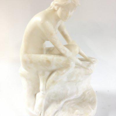 A marble figure of a nude seated woman, 23cm tall.