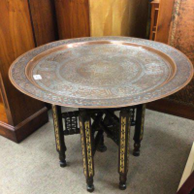 An Early 20th century or late 19th century Middle Eastern white metal inlaid Copper Circular shaped tray table. on a folding inlaid base. Diameter 70cm.