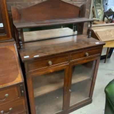 A Victorian mahogany chiffonier, the raised back above two drawers and a pair of glazed doors in a plinth base. 90cm x 40cm./