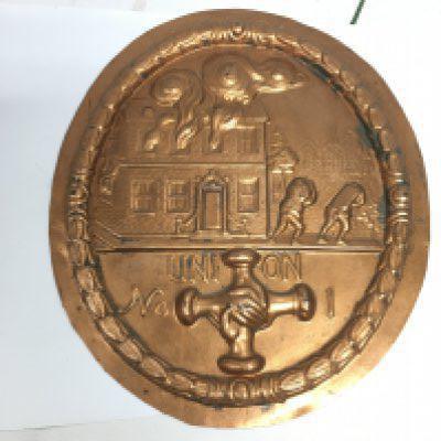 A copper fire plaque, approx width 18.5cm. Shipping category B.