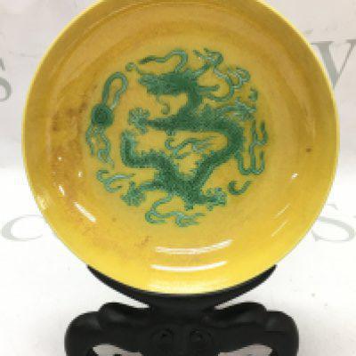 A yellow glaze dragon dish with a four character mark at the base. 14cm wide. This lot cannot be posted
