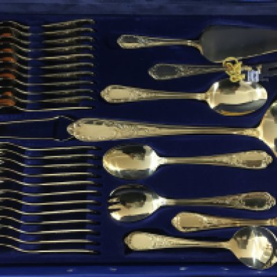 Golden cutlery including large spoons, tablespoons, teaspoons, forks, knives and other cutlery items. Chromstahl cutlery set including 23K gold plate cutlery. Nearly all of the utensils are there and made in Germany.