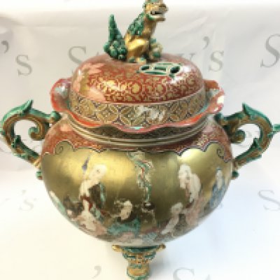 A Chinese vase decorated in gilt and with panels of figures and a peacock , twin handled design, topped with a Fu dog figure, fu dog feet. 38cm tall 40cm wide approximately. Some damage and restoration