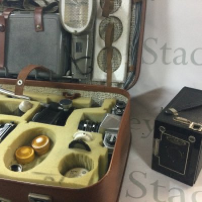 A range of cameras including a vintage camera, includes a large case filled with camera equipment. A duo ensign vintage box camera. There is also 2 Asahi Pentax cameras.