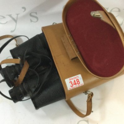 A pair of binoculars with a bag made by Lowerpro including cameras from Canon and more and photography equipment.