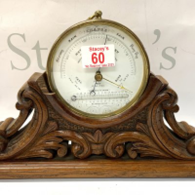 A late Victorian brass cased barometer by Cragg of Colchester with carved oak stand.