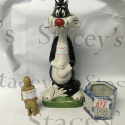 One oriental figure and a blue and white pot. Also, there is a 1978 Sylvester the Cat liqueur amaretto bottle.