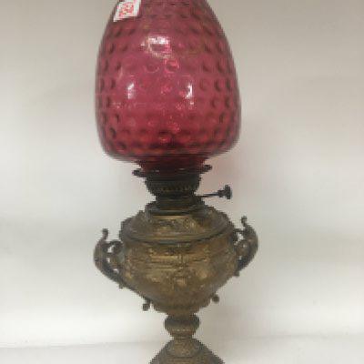 A Victorian oil lamp with an elaborate Spelter base and cranberry shade damaged.