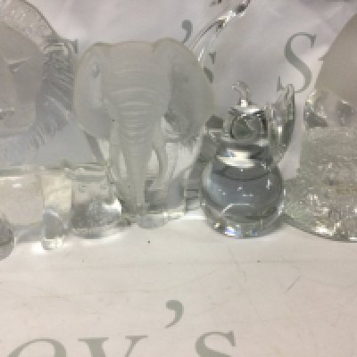 A collection of glass decanters, glass items and glasses, some handmade and in the shape of animals.