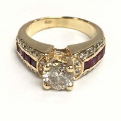 9ct gold ring set with a raised central diamond with further diamonds and red stones on the shoulders. Central diamonds 1.01ct and other diamonds Approx 0.09ct Size M