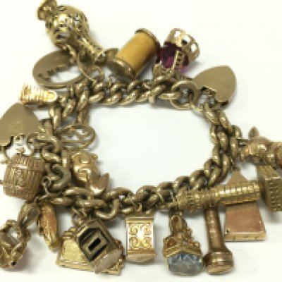 A 9ct gold charm bracelet, approximately 120g total weight. Postage category A