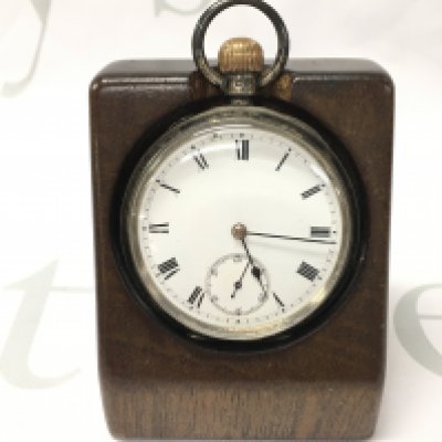 A hallmarked silver Waltham pocket watch with a wooden stand.