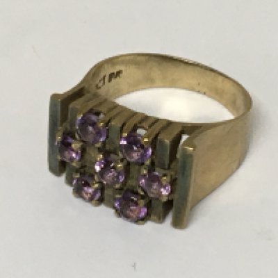 A 9carat gold modern design ring set with a pattern of amethyst stones. Weight 6.5g