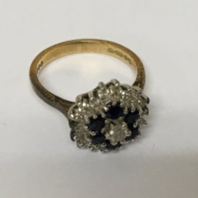 A ladies 18carat gold ring set with a pattern of diamonds and sapphire. Weight 4.4g