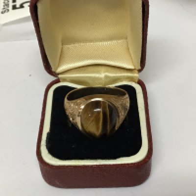 A Gents gold ring set with a Tigers eye stone gold hallmarks worn weight 9g