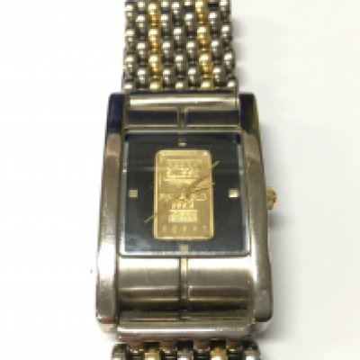 A stainless steel watch set with a 1 gram fine gold bar in the dial.