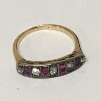 An unmarked worn marks gold ring set with ruby coloured stones and white stones weight