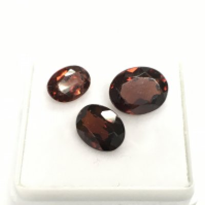 3 unmounted oval cut garnets in box. Approximately 6.84ct total.