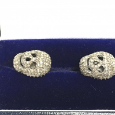 A pair of diamond set skull cufflinks in white metal. Approx 1.55ct diamonds.