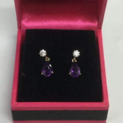 A pair of 9ct gold drop earrings set with a diamond and amethyst. Shipping category A.
