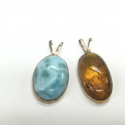 Two 14ct gold pendants comprising one set with amber and one other. Shipping category A.