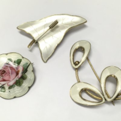 Three enamel brooches including a Norwegian sterling silver brooch and other silver brooches . Postage category A