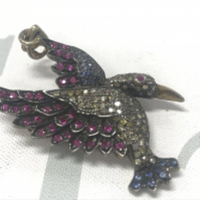 Silver gilt bird brooch/pendant set with rubies, sapphires and diamonds. Rubies 0.50ct approx.