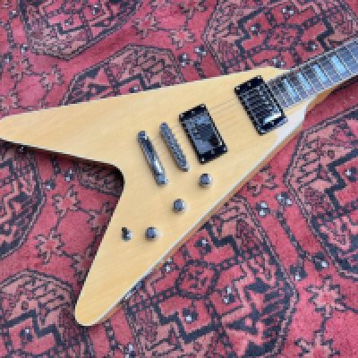 A 2018 Reverend Volcano V Guitar. Now Discontinued model. Blonde Finish. All original and unplayed condition with factory plastic still on control cavity cover. Comes with fitted V Shape Reverend Case.