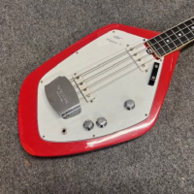 A 1965 Vox Phantom IV Bass Guitar. An Italian made Eko Factory Vox Phantom Bass V209 Model with the angular body shape. Red with all original parts. Some touch up paint to sides and missing rear back pad. General condition good with signs of playwear consistent with age and use.