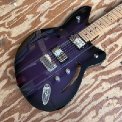 This is a Reverend Airsonic fixed bridge model electric guitar in Periwinkle Burst with maple board. Made in Korea. Unplayed condition and factory plastic still on rear switch and control cavity covers. No gig bag or case.
