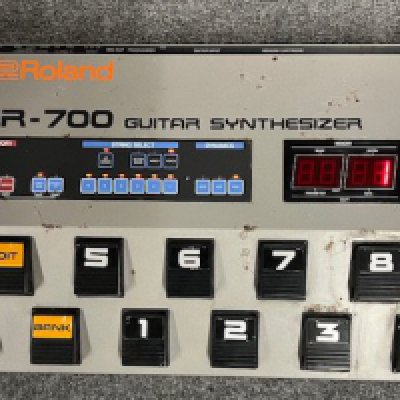 A 1980's Roland GR 700 Guitar Synthesizer. Seen working and tested. In fair condition with some wear to outer casing. Comes with Roland GR connector