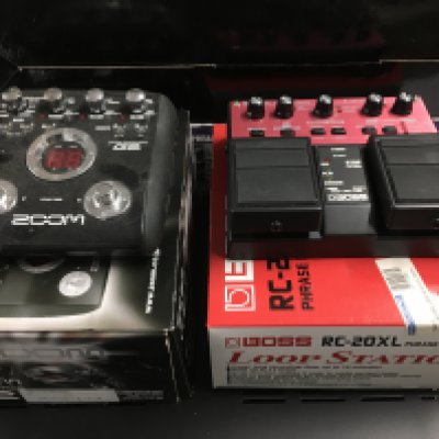 Two boxed effects pedals comprising a Boss RC-20XL phase recorder and a Zoom G2.