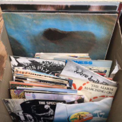 A box of LPs and 7" singles by various artists including David Bowie, Pink Floyd, The Alarm, The Specials and others.