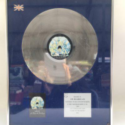 A framed and glazed Queen 'A Day At The Races' silver disc in recognition of sales worth more than &#2013266275100,000, approx 41.5cm x 51.5cm.